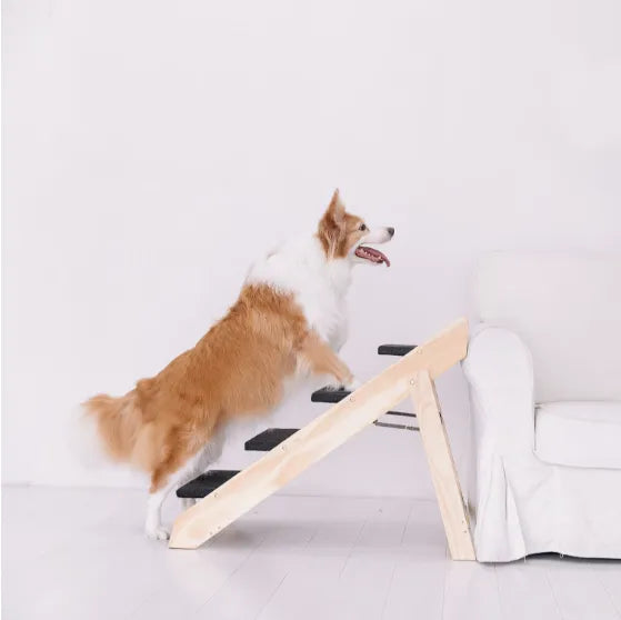 A dog using the four wooden pet steps beside a sofa